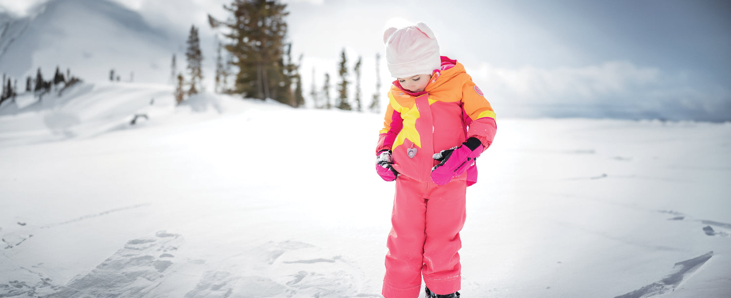 A little girl playing in the snow while wearing Obermeyer.