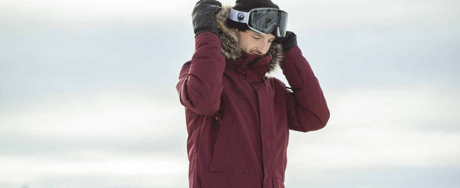 Man adjusting his hood wearing an Obermeyer Ridgeline Parka